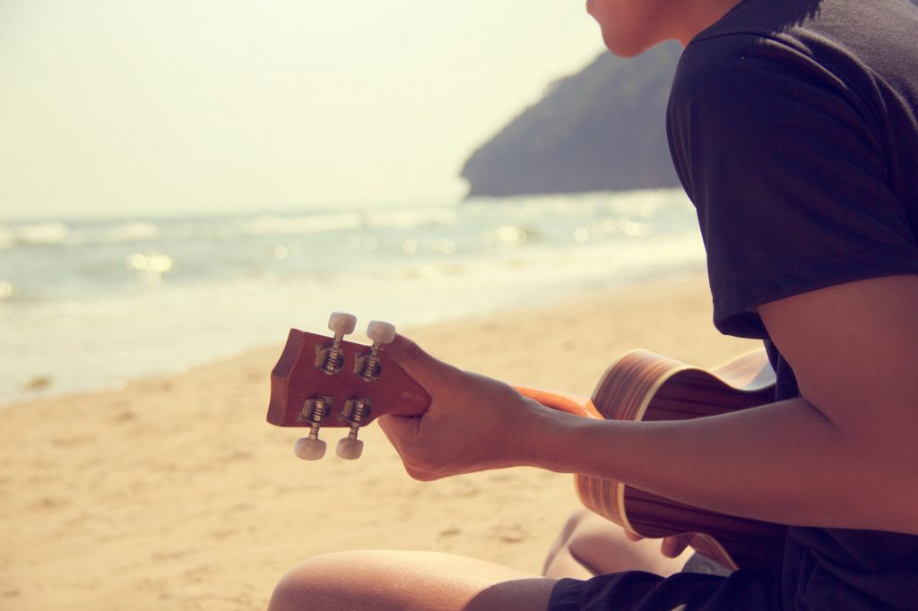 Man playing ukulele on the beach